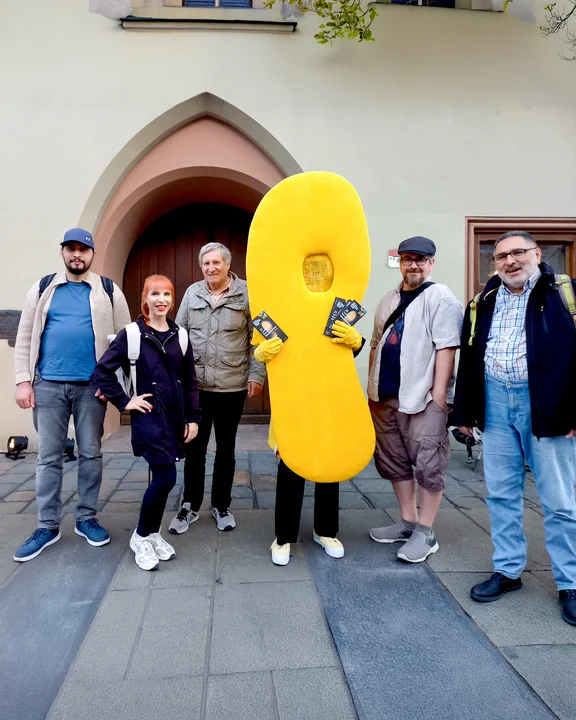Menschengruppe vor der Kirche mit einem riesigen gelben Fuß