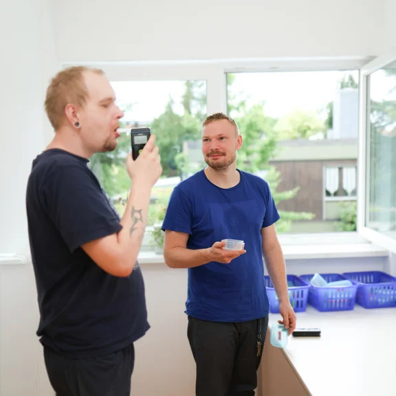 zwei Männer, ein Mann macht einen Alkoholtest